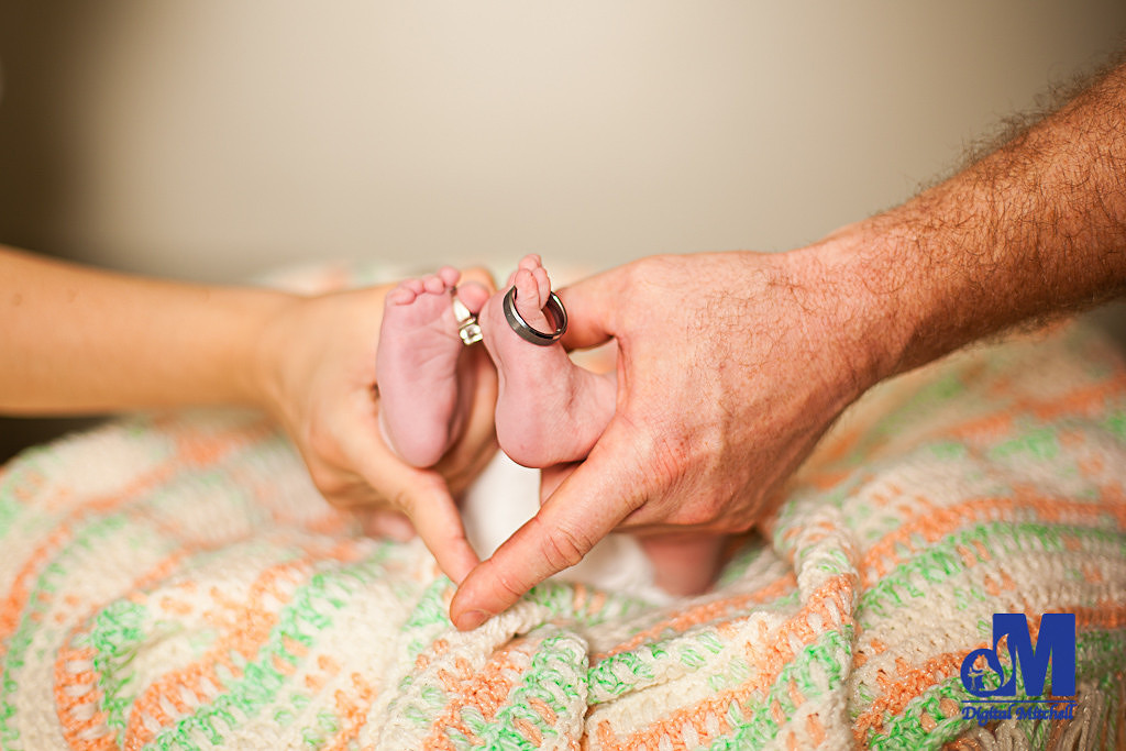Baby with mom and dad hands