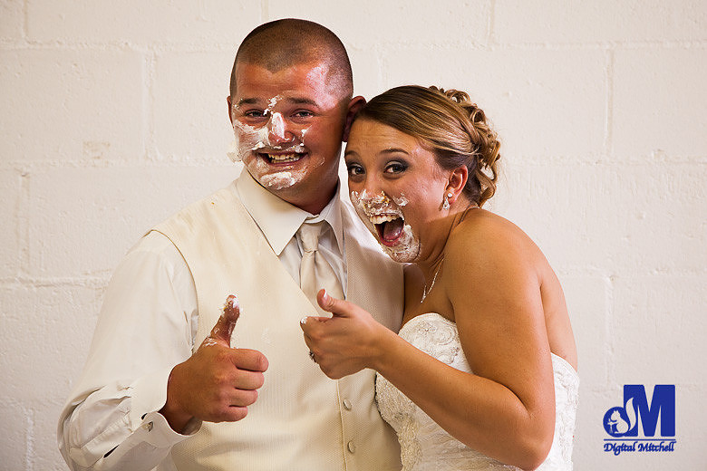 Photograph of bride and grom with cake on face