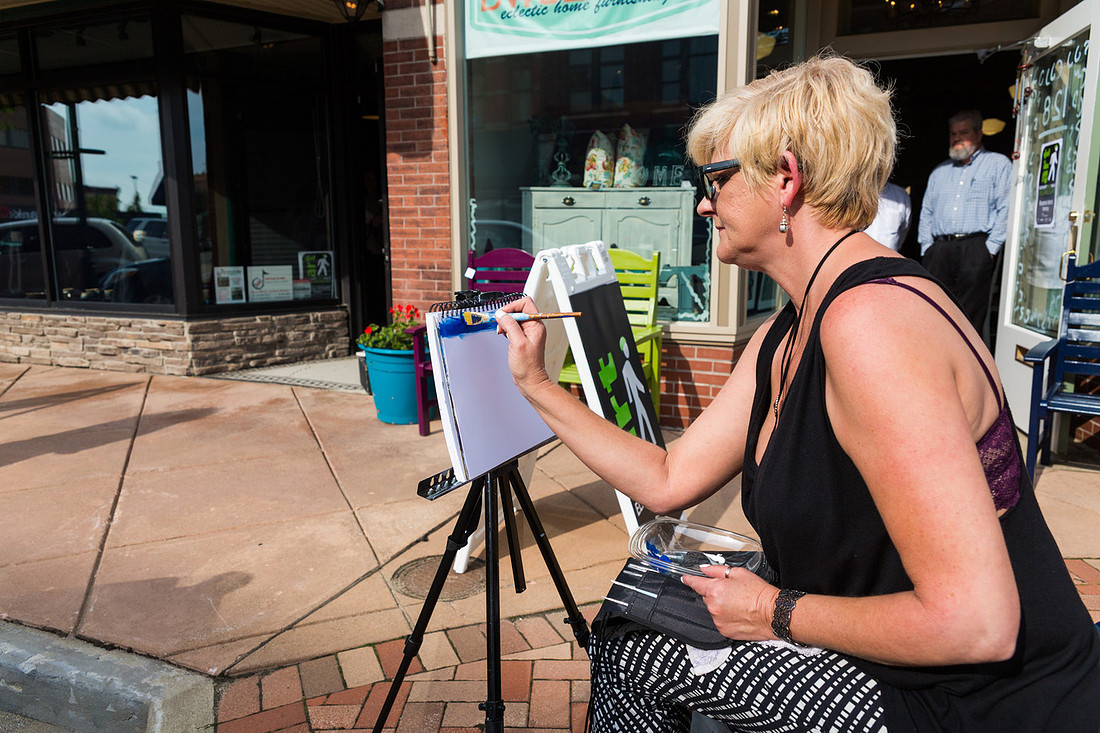 picture of an artist painting on the sidewalk