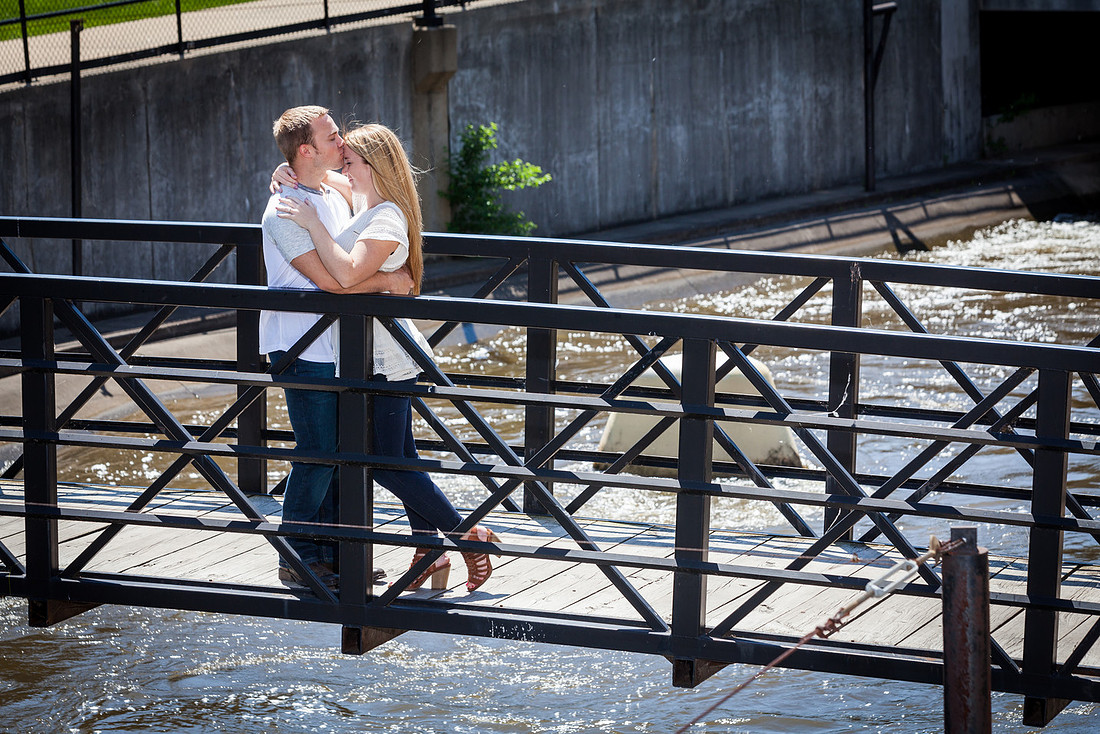 Kiss on the head while the couple stands on a bridge