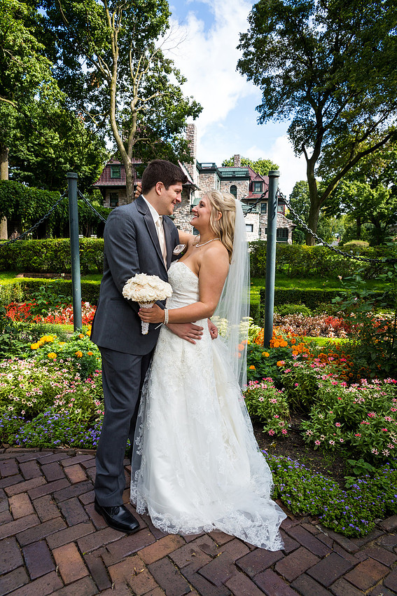 picture of an embracing bride and groom by a mansion