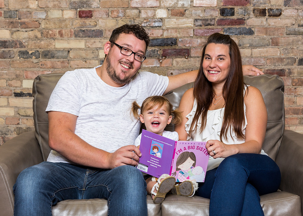 picture of mother, father and baby reading book