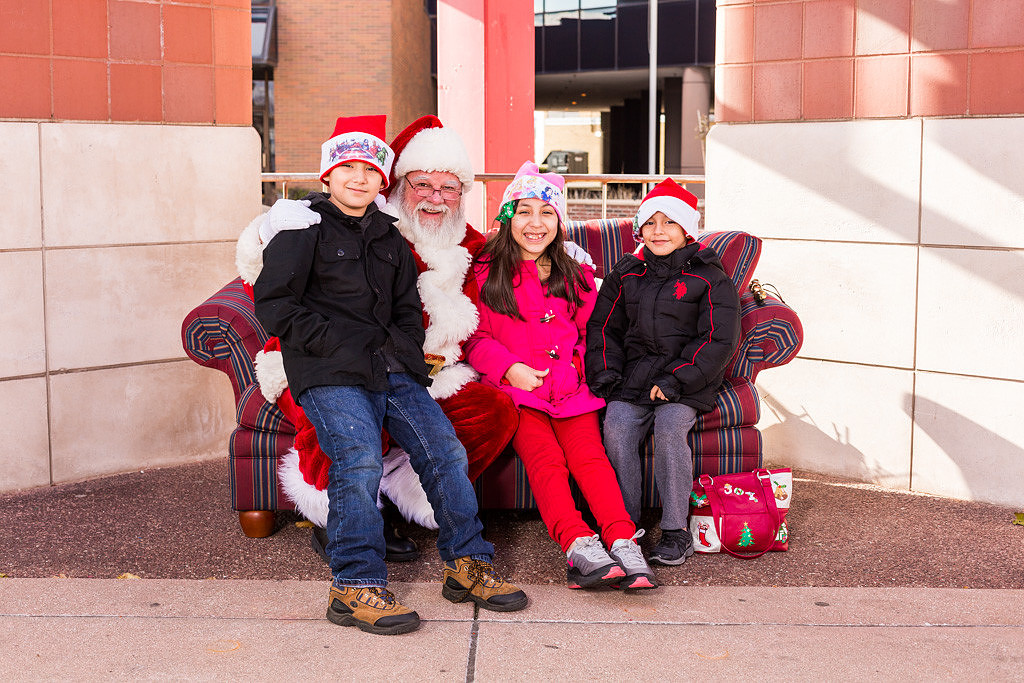 picture of Santa with kids wearing Christmas hats.