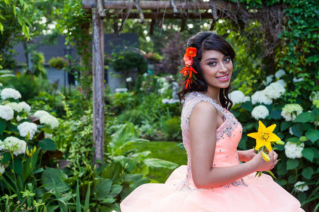 picture of young girl in Quinceañera holding aflower