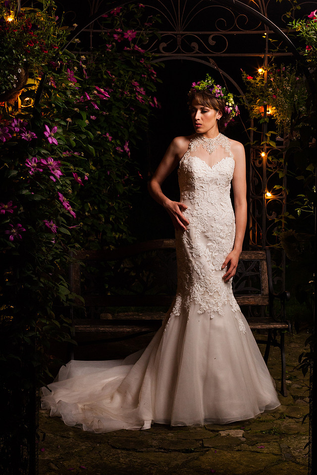 picture of bride at night in a garden under a big bird gage
