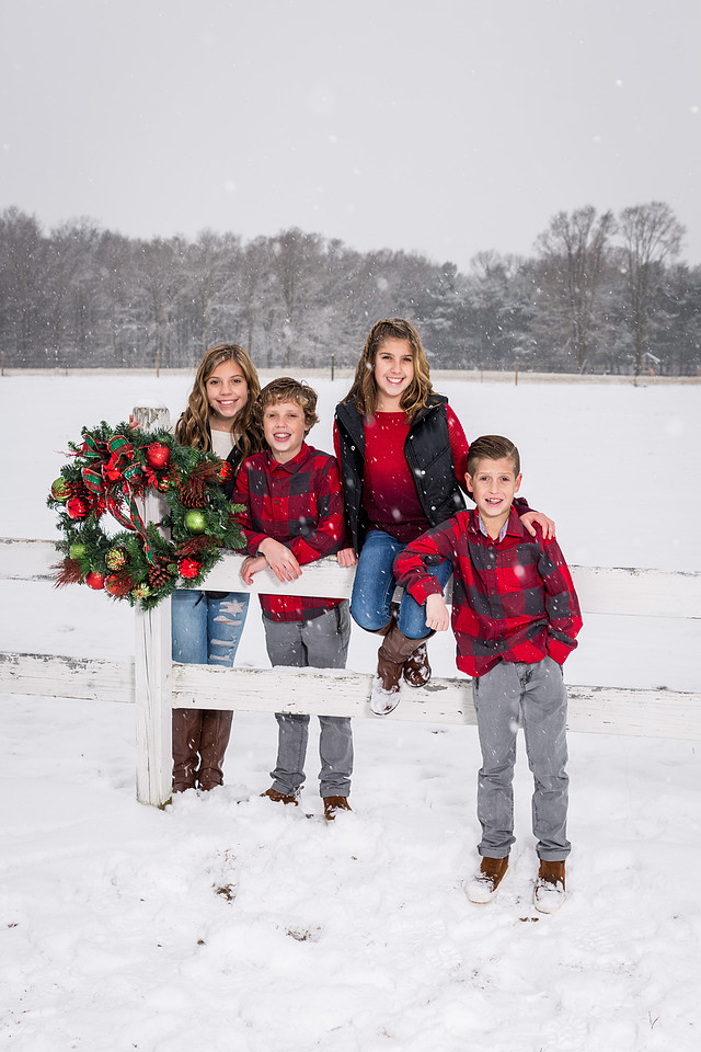 picture of kids sitting on a fens in the snow