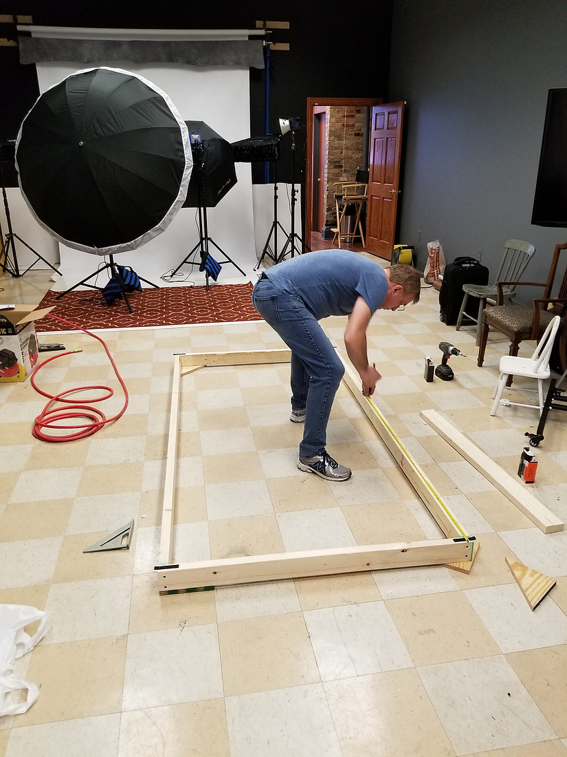 picture of man measuring lumber for photography set