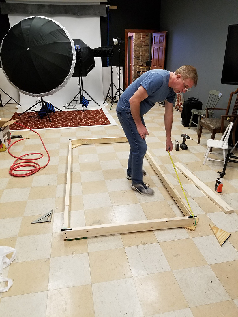 picture of man measuring lumber for photography set