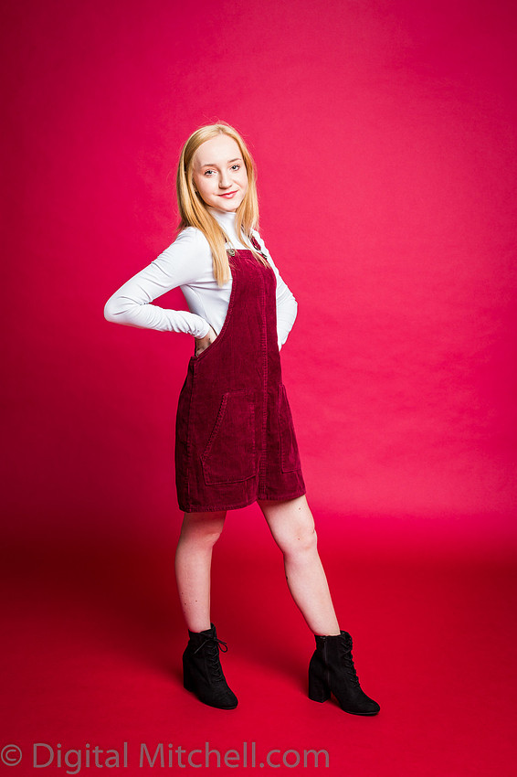 photograph of blonde girl on red paper in a red dress