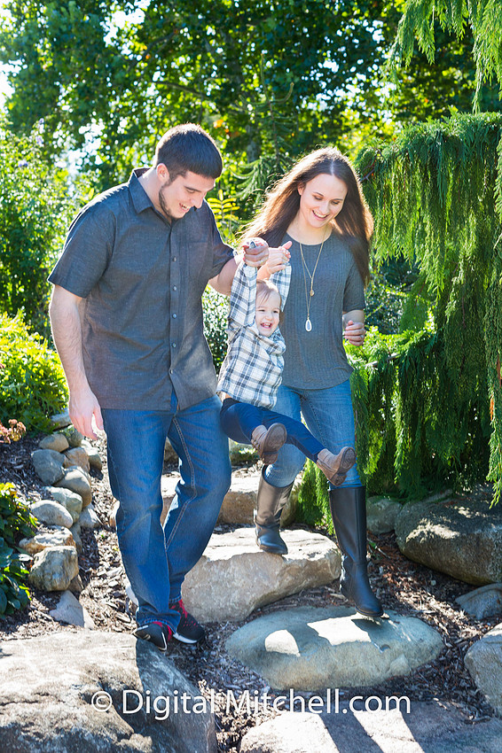 picture of child being swung by her parents at fall photo session